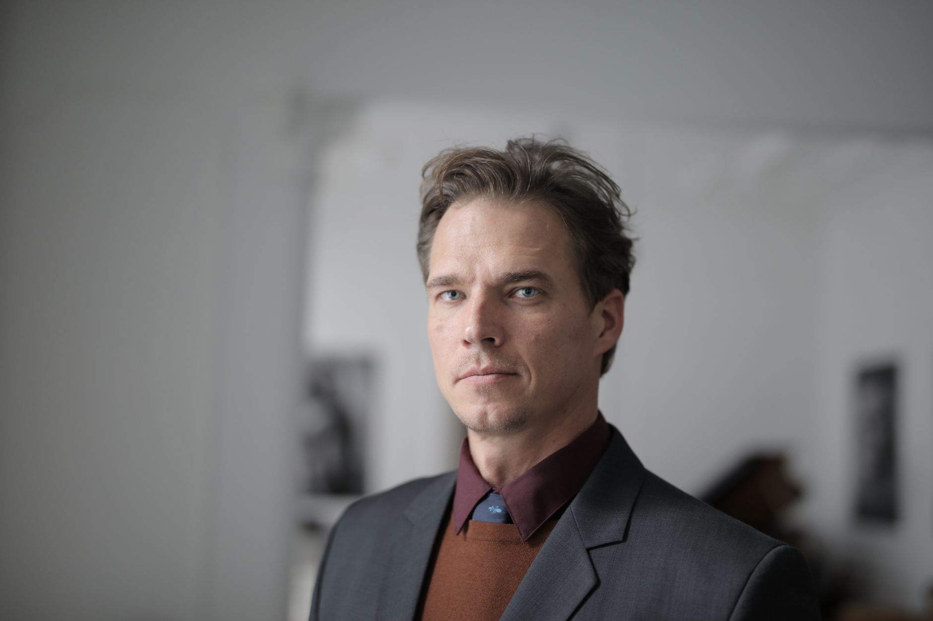 Professional corporate headshot of a man in a suit against a neutral background