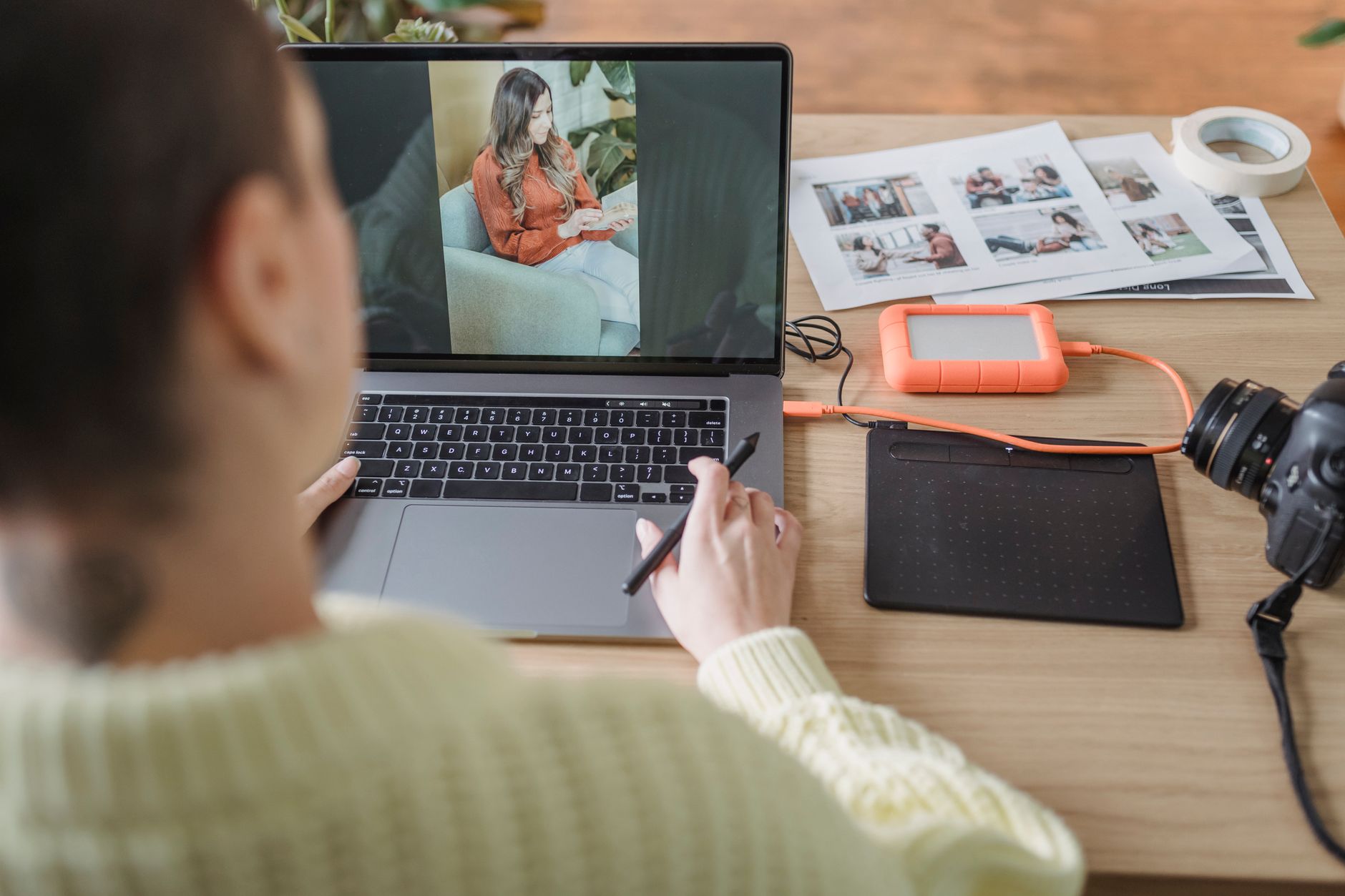a photographer editing a portrait photo on a desktop computer with noise reduction software