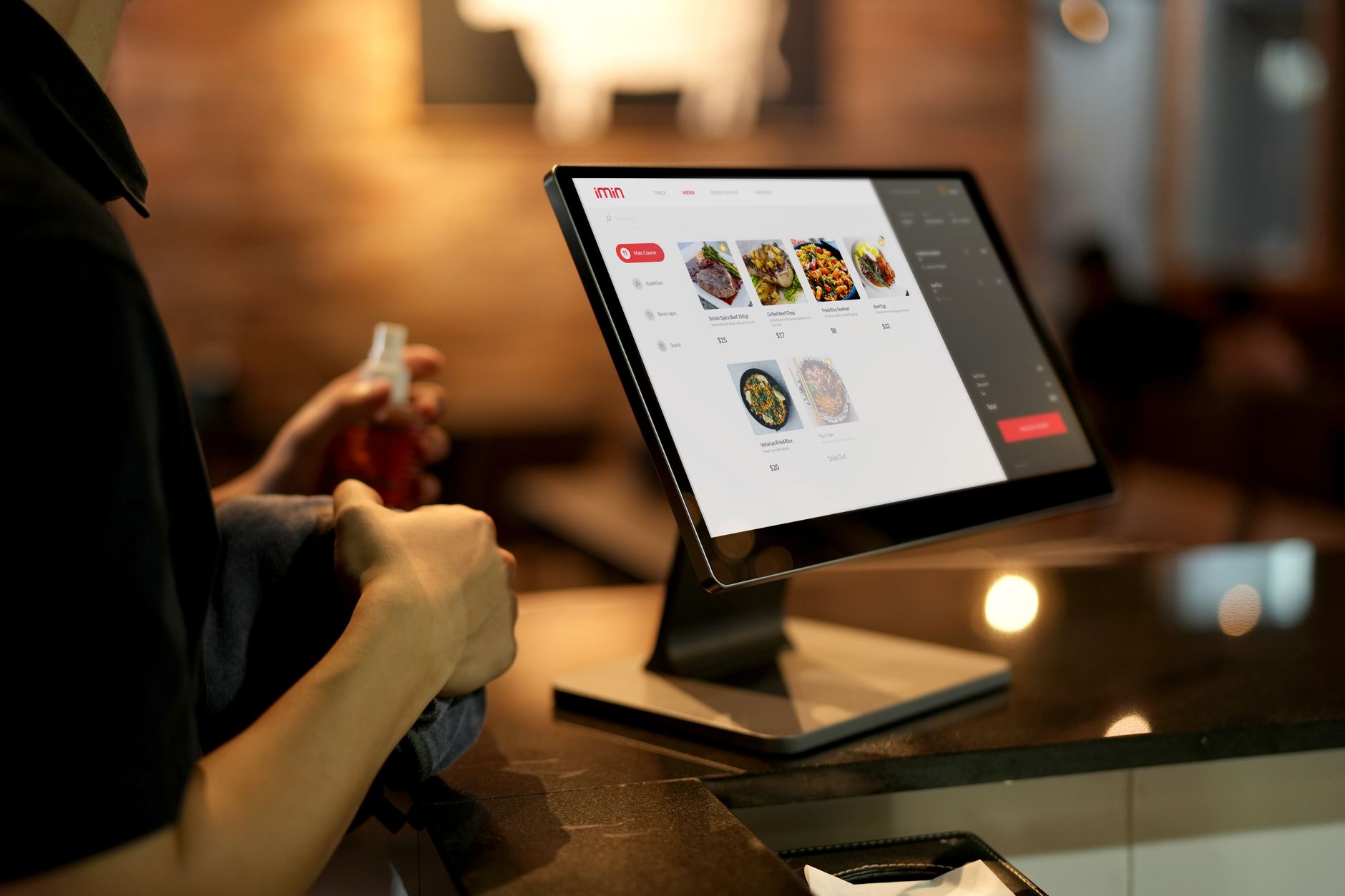 a restaurant owner holding a tablet and reviewing a digital menu in a commercial kitchen
