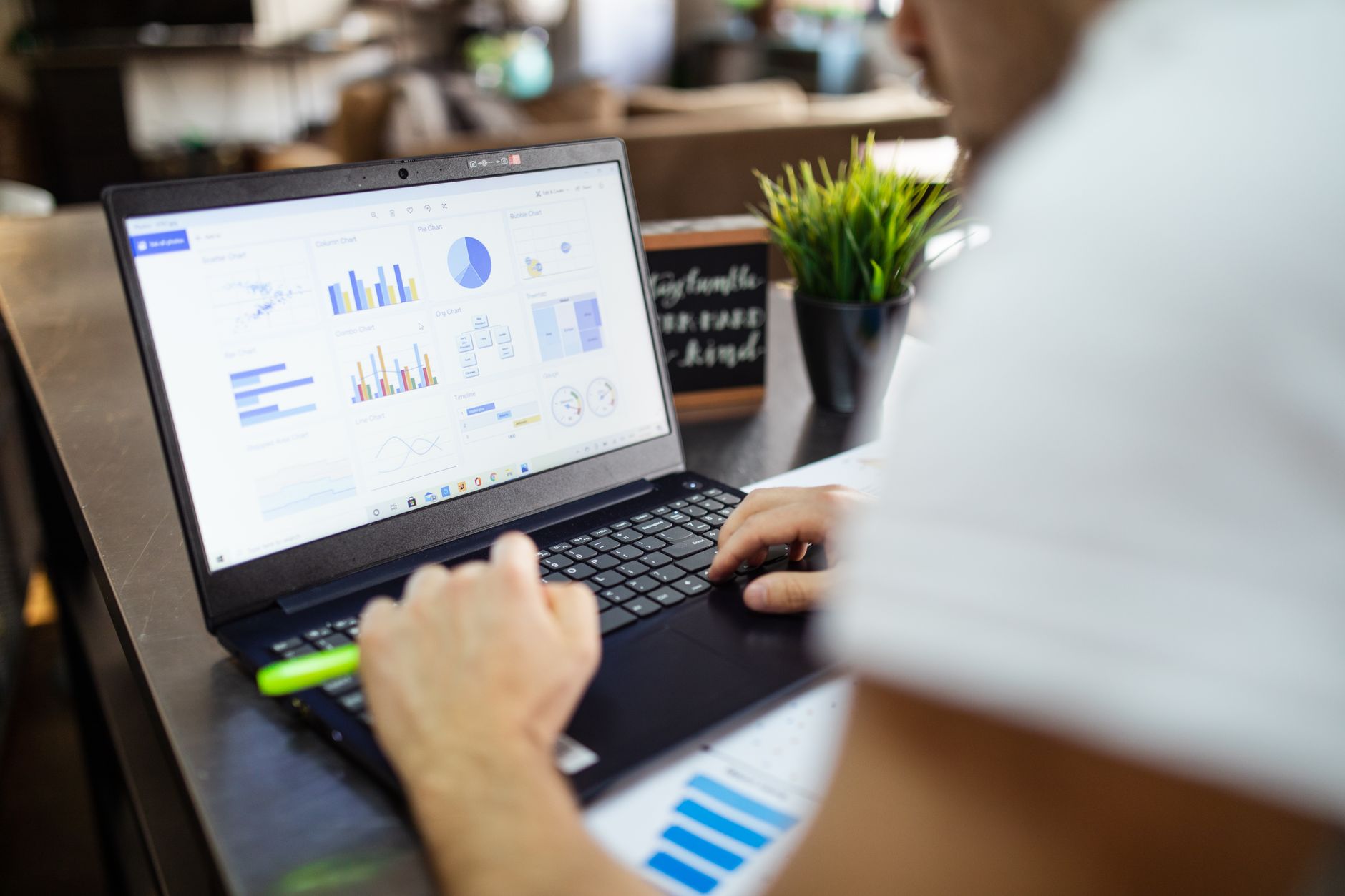 a restaurant manager using a laptop showing Google Docs and a spreadsheet on screen