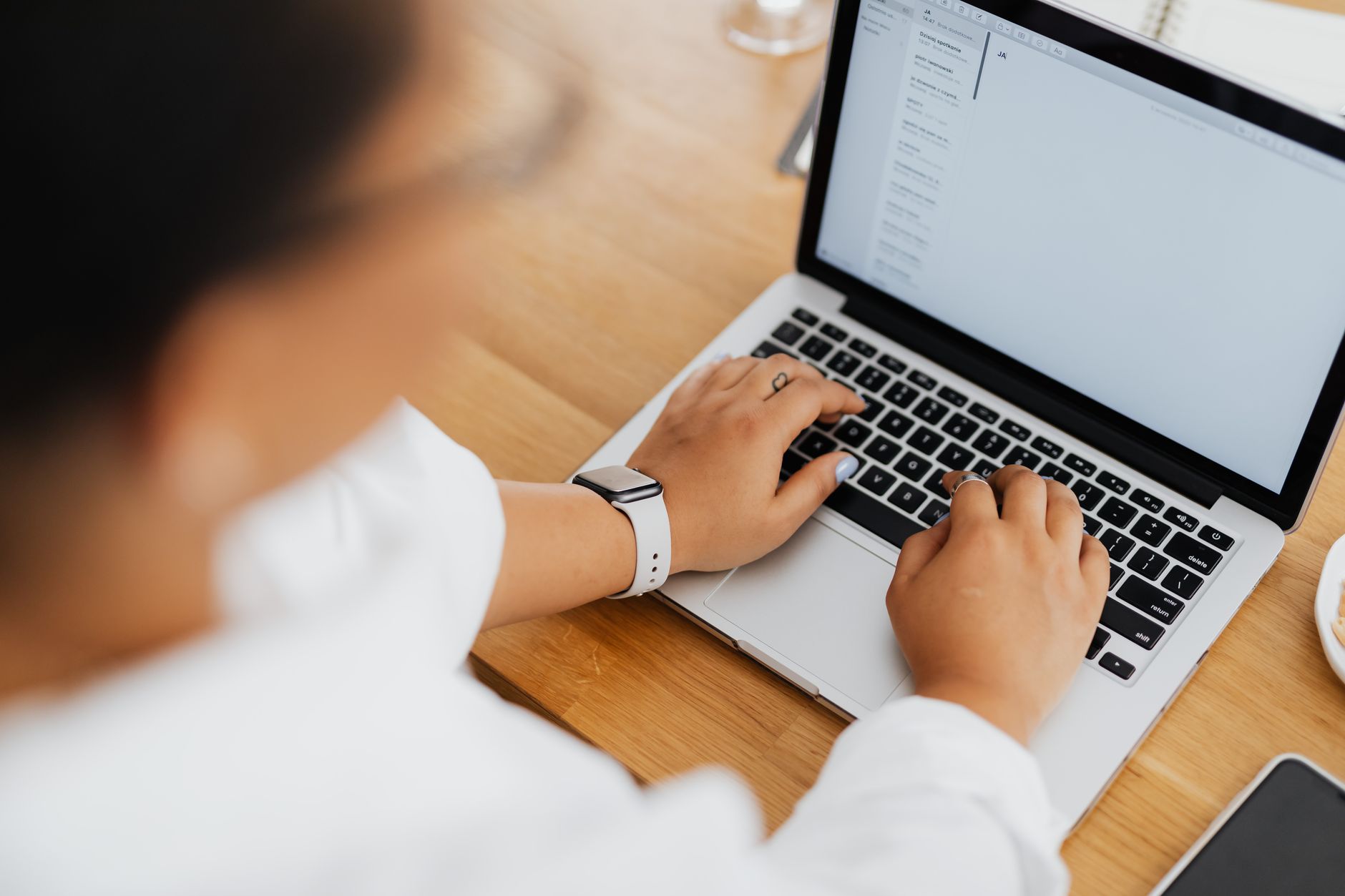 a person writing personalized outreach emails on a laptop while viewing a CRM dashboard