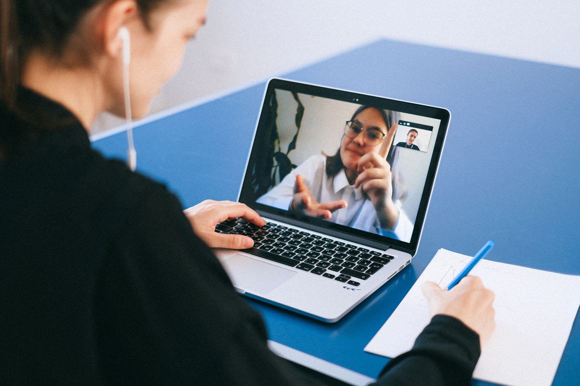 a sales team in a video meeting with AI transcription notes visible on a second screen