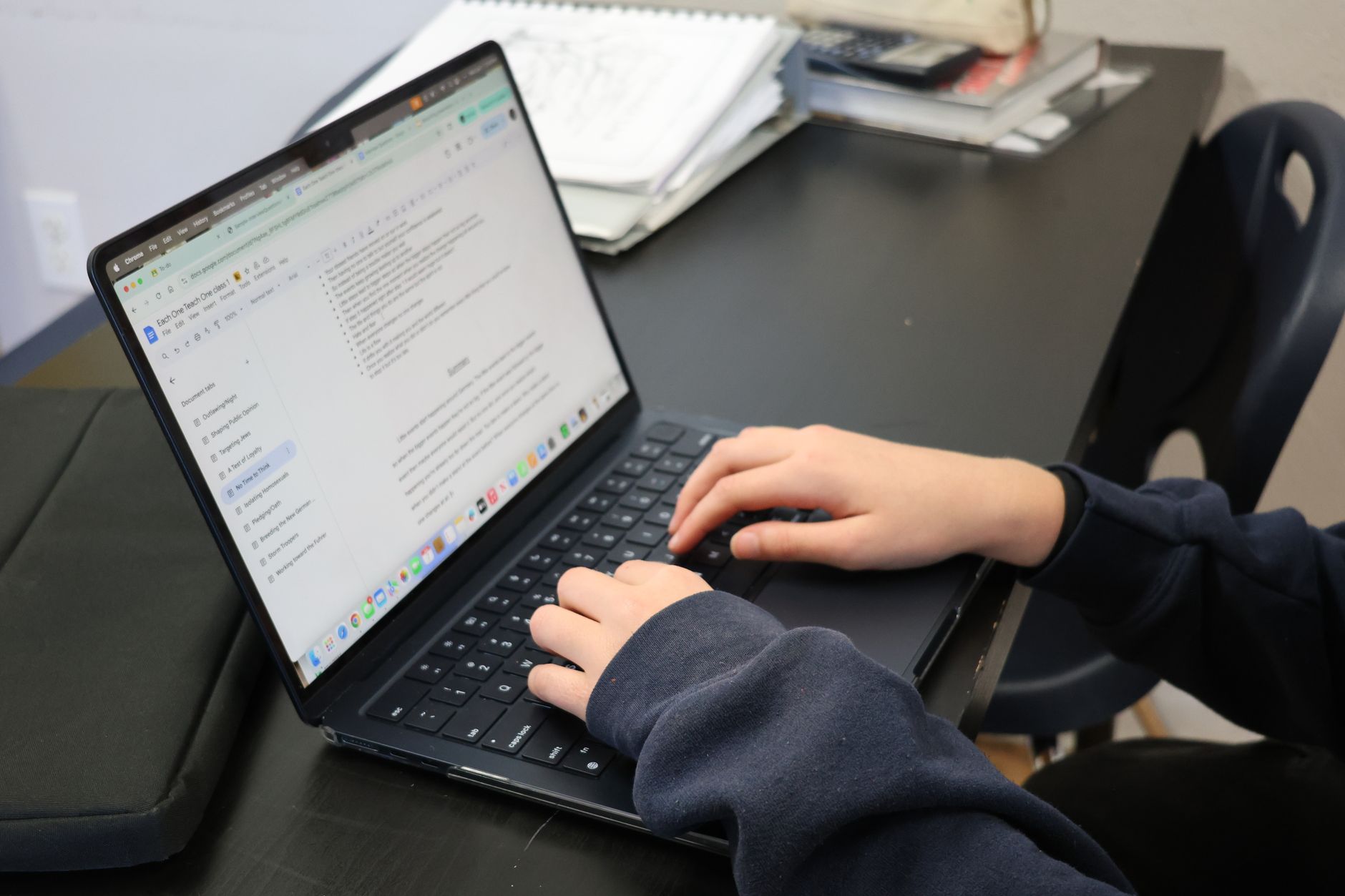 hands typing on a laptop with a draft document open on the screen