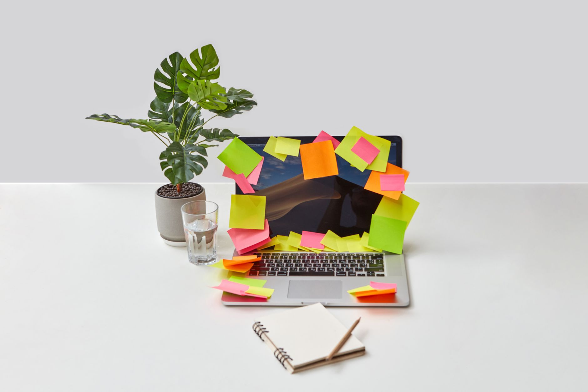 A person setting up an automation workflow on a laptop, with colorful sticky notes on the wall behind them.