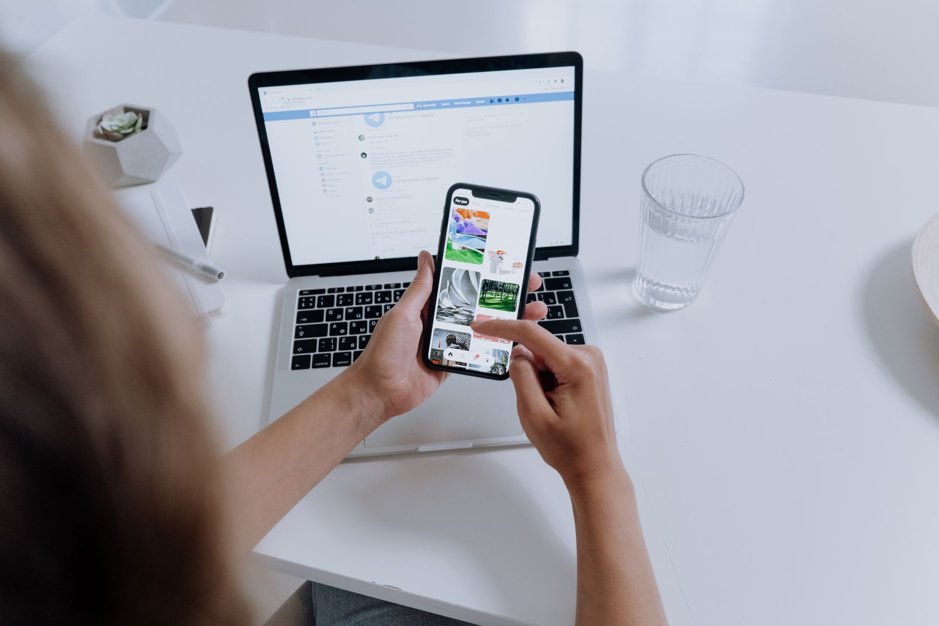 A marketer comparing AI generated social media images on a laptop and phone.