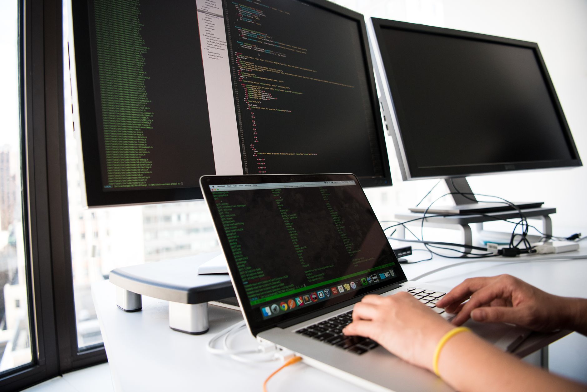 Developer reviews multiple code files on split screen with AI diff highlights