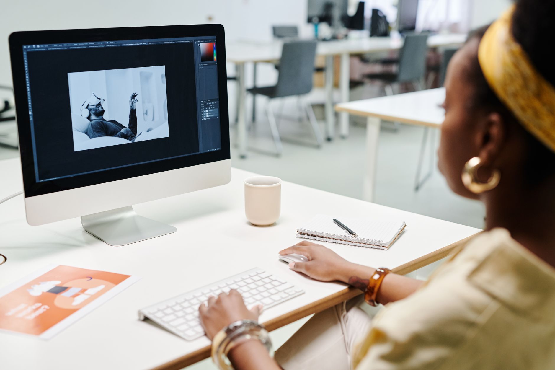 Graphic designer editing digital photo on computer screen in creative office