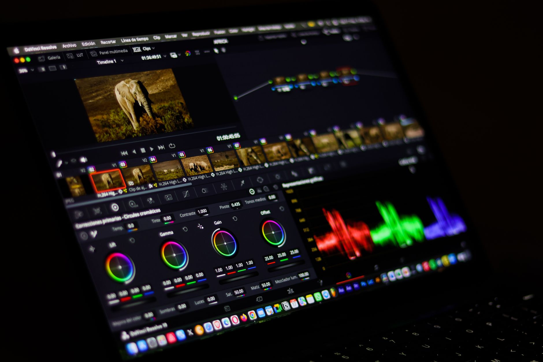 A person editing a cinematic video project on a laptop with color grading software open